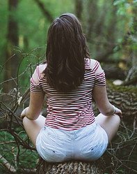 Woman sat on a log in a forest